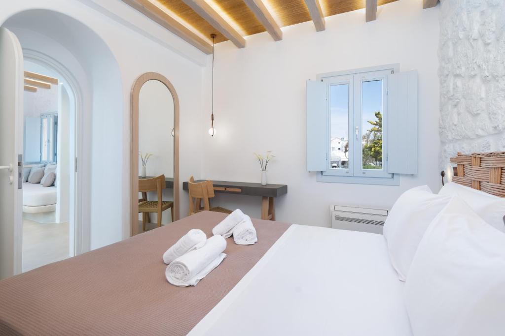 biała sypialnia z białymi ręcznikami na łóżku w obiekcie Airth Santorini Suites w mieście Firostefani