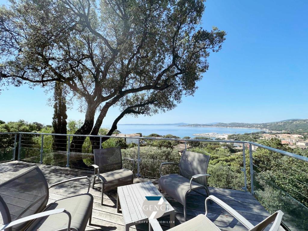 a patio with chairs and a table and a tree at Villa IBIZA in Les Issambres