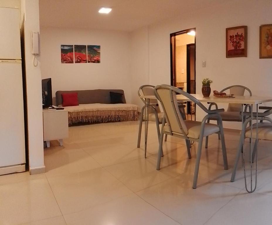 sala de estar con mesa, sillas y cama en Departamento Alberdi en Córdoba