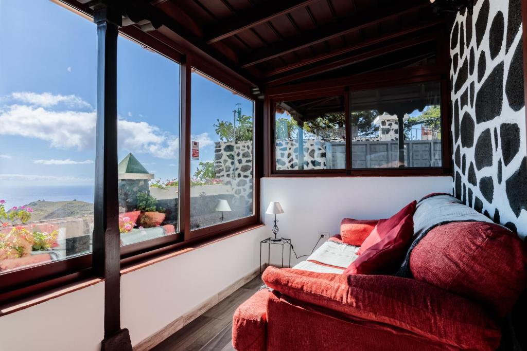 Habitación con ventanas y sofá con vistas. en Casa Don Rodnico en Lodero
