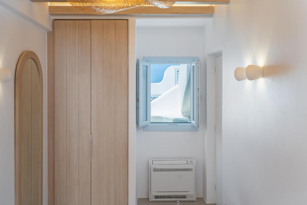 przedpokój z oknem w pokoju w obiekcie Airth Santorini Suites w mieście Firostefani