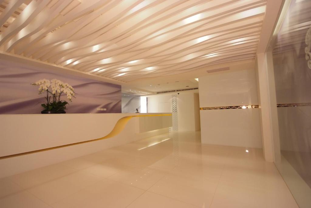 a hallway with a ceiling with a vase of flowers at Hotel Purity in Xinzhuang