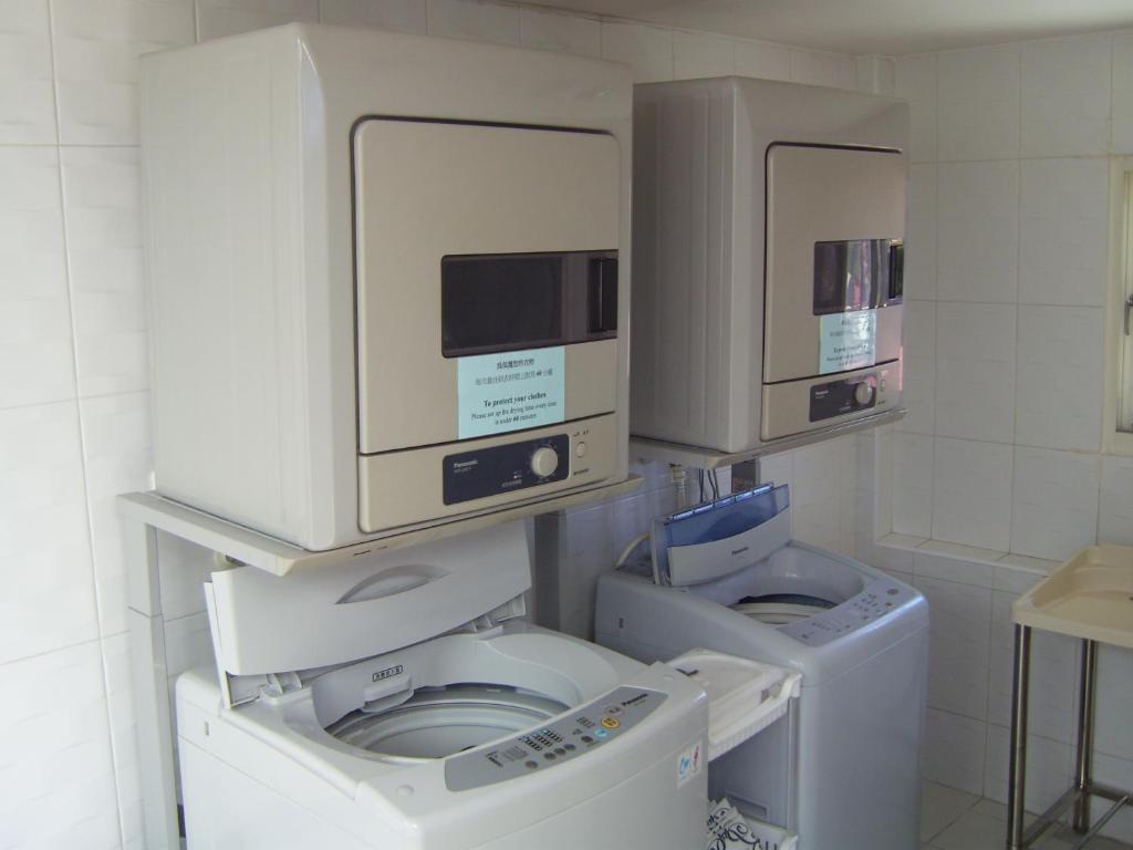 two washing machines and a washer and dryer in a room at Hotel Purity in Xinzhuang