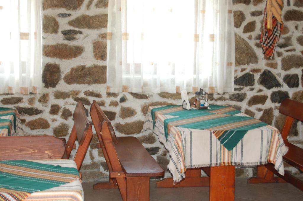 a dining room with two tables and a window at Хотел Варненци in Lŭki