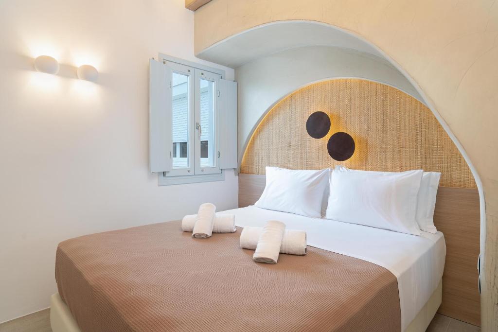 sypialnia z dużym łóżkiem z dwoma ręcznikami w obiekcie Airth Santorini Suites w mieście Firostefani