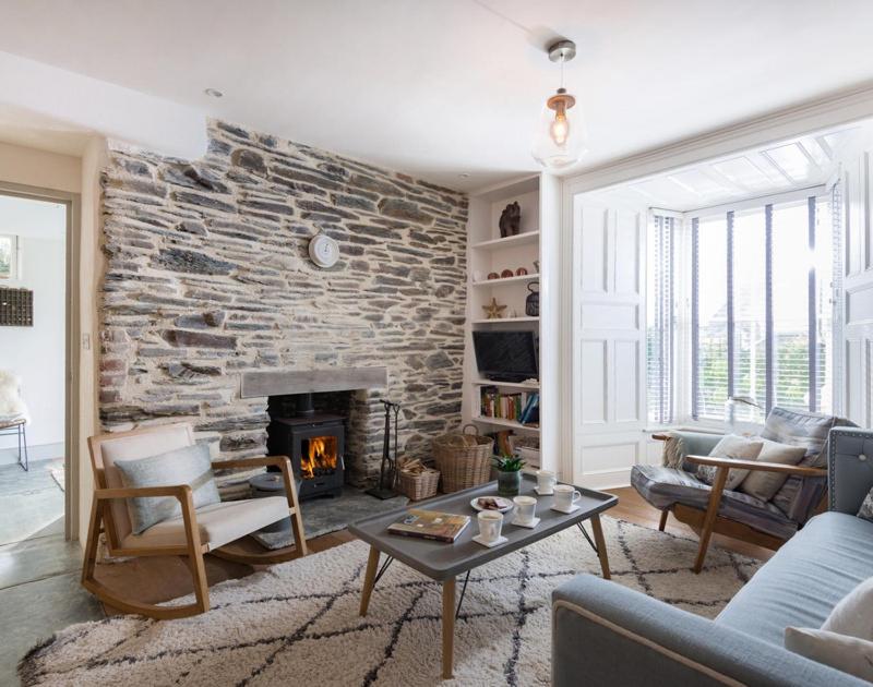 a living room with a stone wall and a fireplace at Albany in Port Isaac