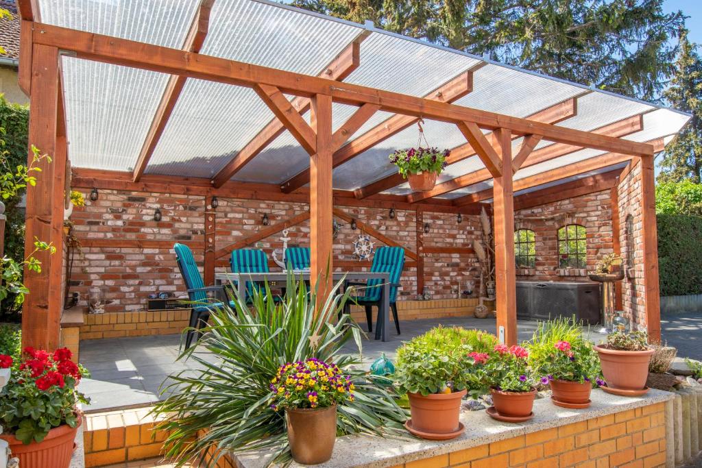 een houten pergola met potplanten op een patio bij Ferienwohnung am Greifswalder Bodden in Lubmin