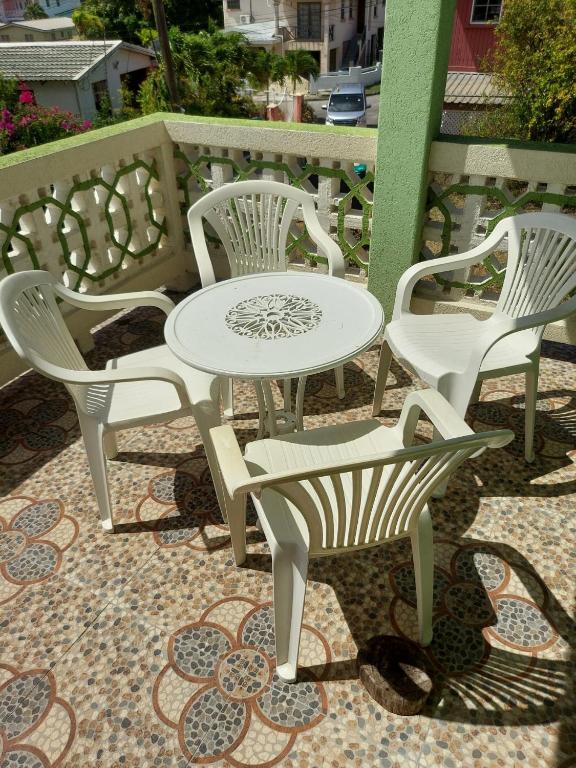 - une table et des chaises blanches sur la terrasse dans l'établissement Pine Breeze Apartments, à Bridgetown