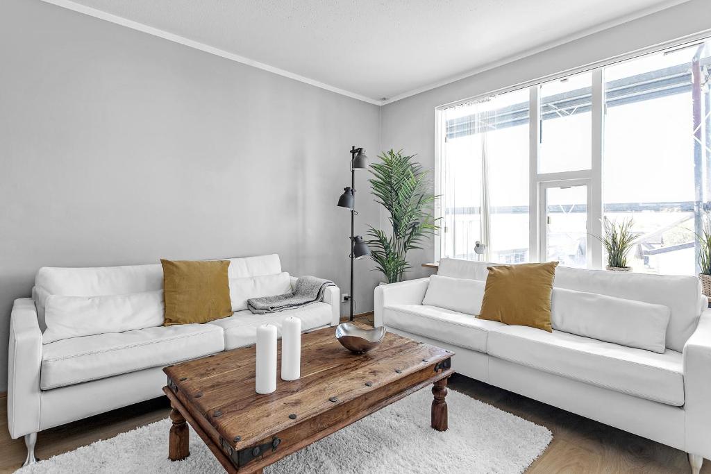 Sala de estar con 2 sofás blancos y mesa de centro de madera en Charming, 2 Bedroom Seaside Apartment en Reikiavik
