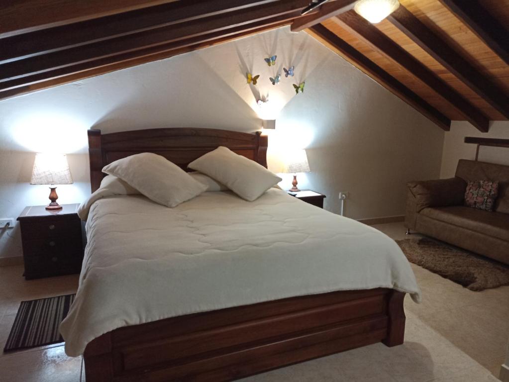 ein Schlafzimmer mit einem großen Bett und einem Sofa in der Unterkunft Apartahotel saquenzipá in Villa de Leyva