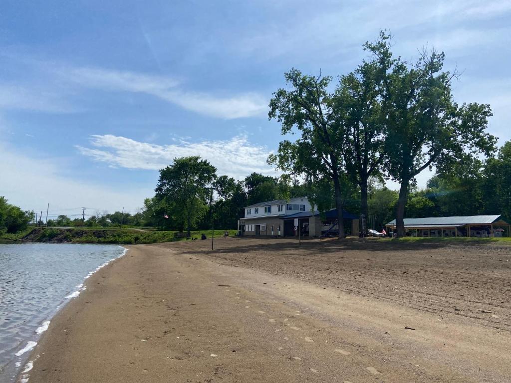 a house on the shore of a beach next to the water at Beach House on Lake in Terre Haute