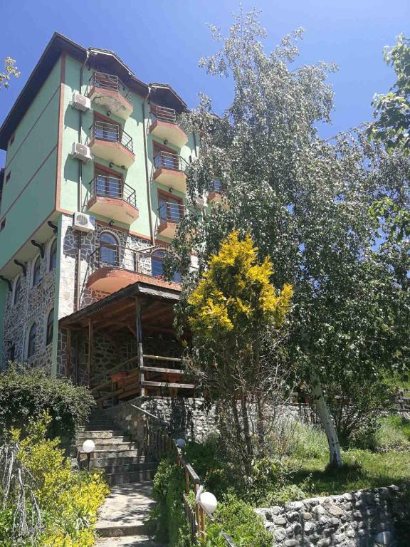 a large building with stairs in front of it at Хотел Варненци in Lŭki