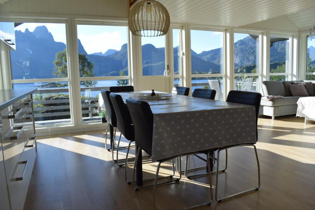 a dining room with a table and chairs with mountains at Hytte i Raftsundet in Digermulen