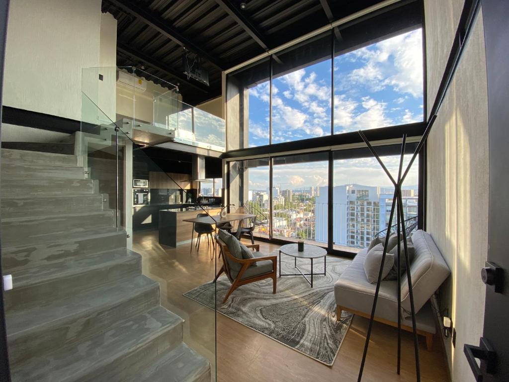 瓜達拉哈拉的住宿－Loft Doble Altura, Colonia Americana @serra，客厅设有楼梯和大窗户