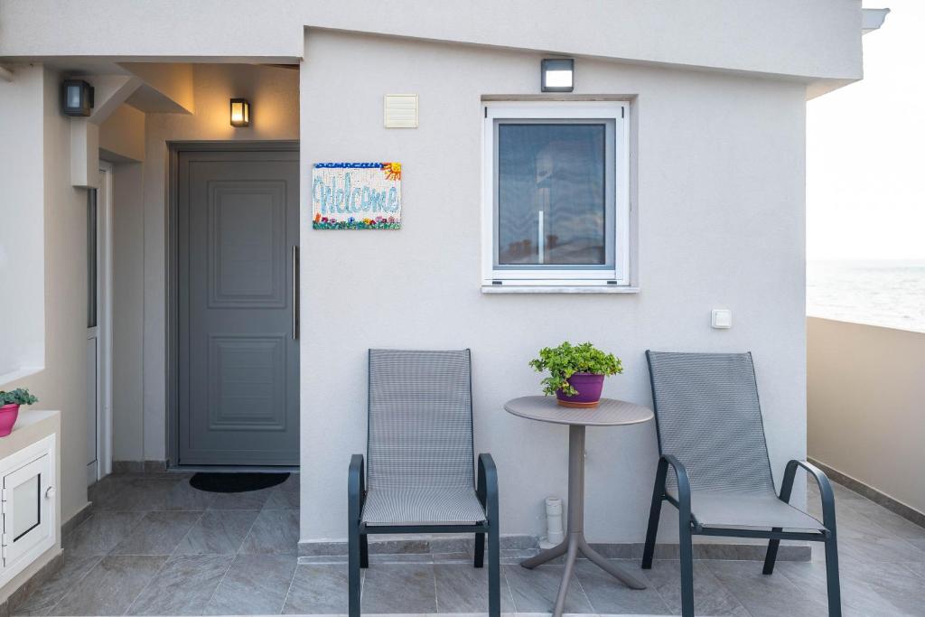 two chairs and a table in front of a house at IONIAN BLUE SUITE in Preveza
