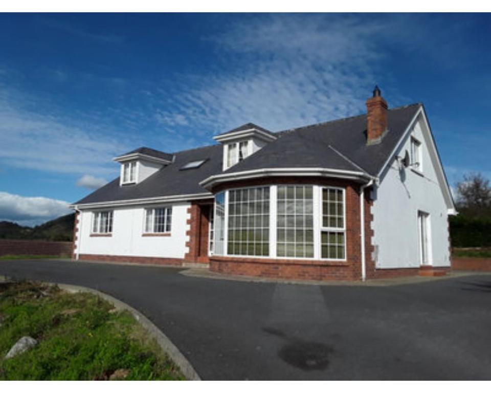 a white house with a black roof at Castleview, Spacious 5 bedroom house with stunning views in Forkill