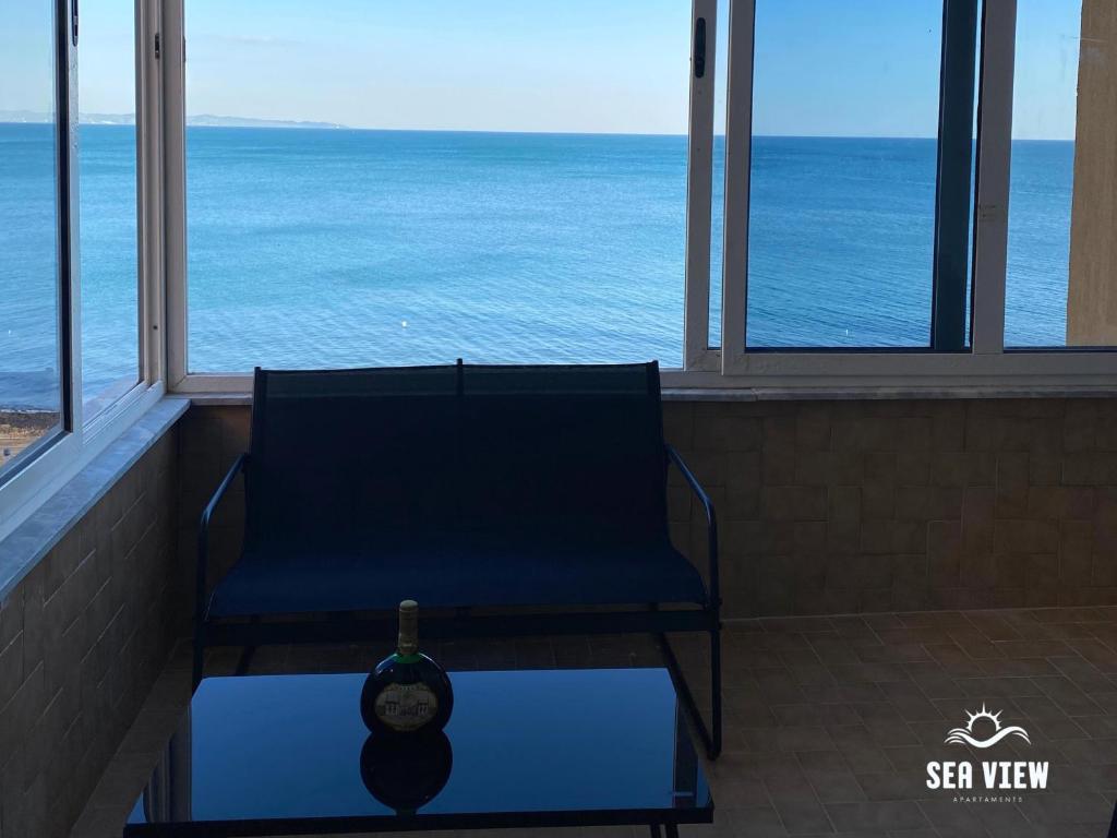 a chair in a room with a view of the ocean at Sea View Apartaments in Durrës