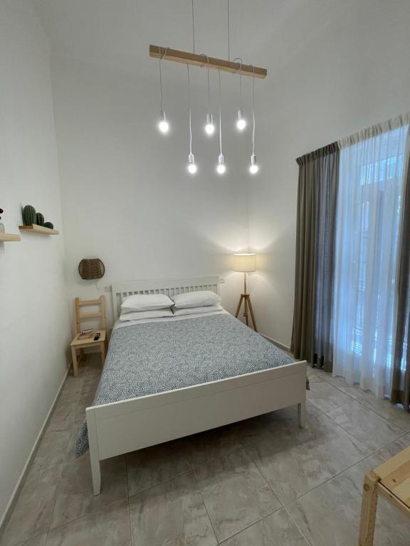 una camera con un grande letto e un lampadario a braccio di DesireHome a Bari
