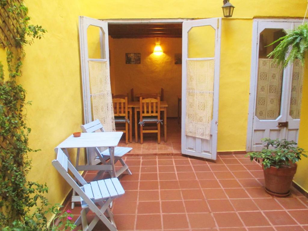 eine Terrasse mit Stühlen, einem Tisch und einer gelben Wand in der Unterkunft La Querencia de Buenos Aires in Buenos Aires