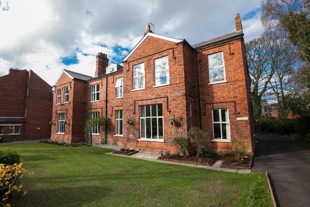 a large red brick building with a grass yard at Gregory by the Warren Collection in Belfast