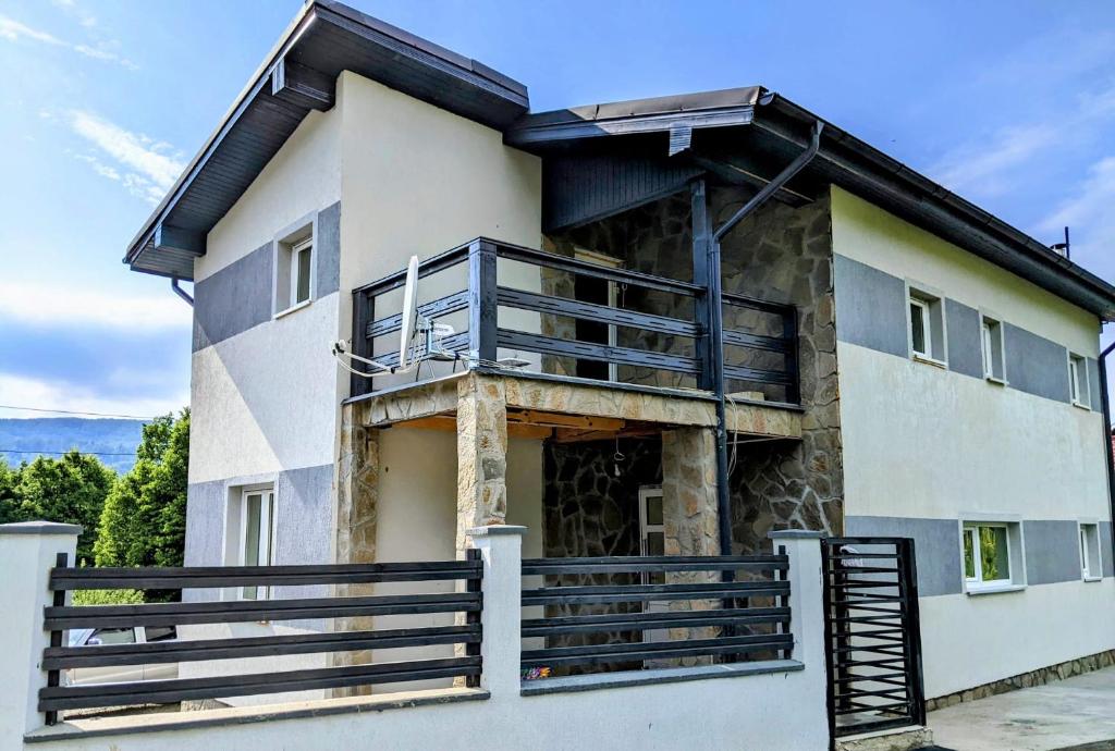 a house with a balcony on top of it at Hill House Valiug Crivaia in Văliug