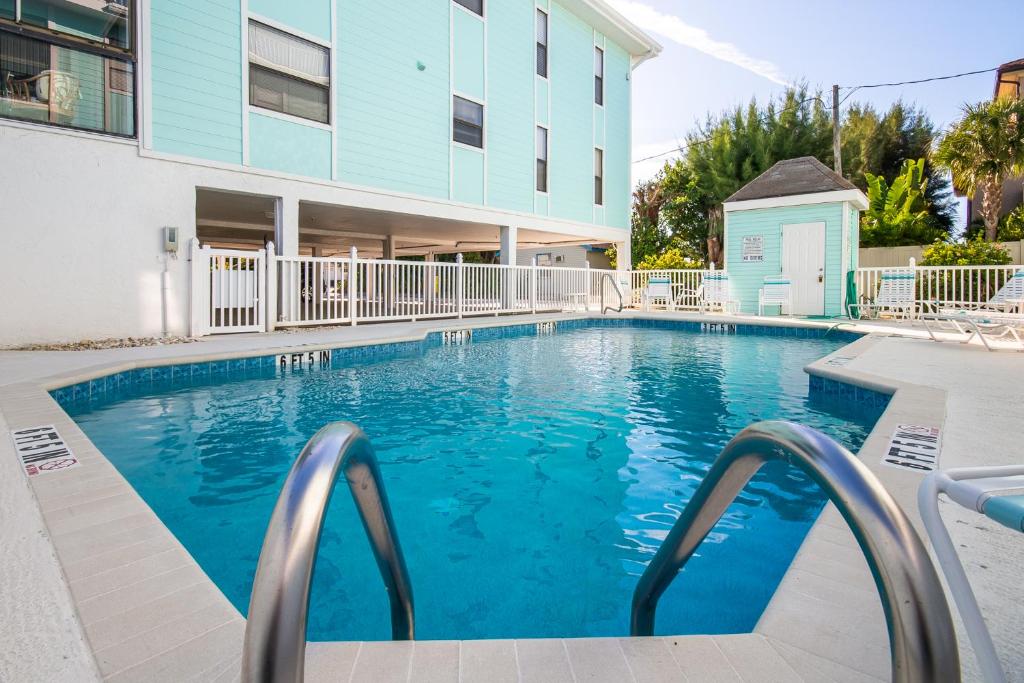 a swimming pool in front of a building at Beach Potato - 3404 Gulf Dr 5 in Holmes Beach