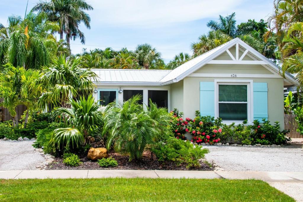 una casa con delle palme davanti di Island Time: AMI North End, Pool, Close to City Pier & Pine Ave by Anna Maria Life Vacation Rentals ad Anna Maria
