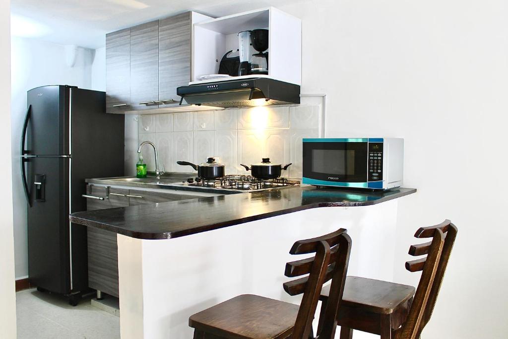 uma cozinha com um fogão e um frigorífico em ApartaDuplex em Yumbo