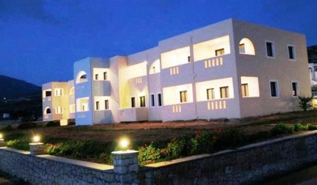 a large white building with lights in front of it at Archipelagos Apartments in Arkasa