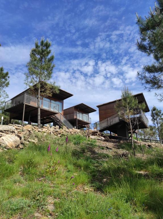a house on top of a hill with trees at Cabañas Mirador de Ézaro in Arcos