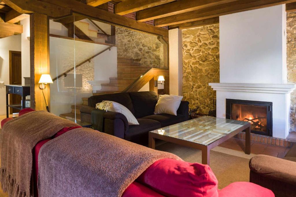 sala de estar con sofá y chimenea en El Zaguán de Cabanillas, en Cabanillas del Monte