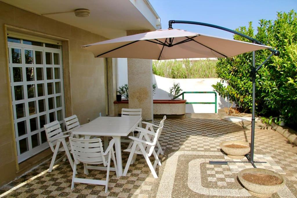 - une table et des chaises avec un parasol sur la terrasse dans l'établissement Villa Giovanna, à San Pietro in Bevagna