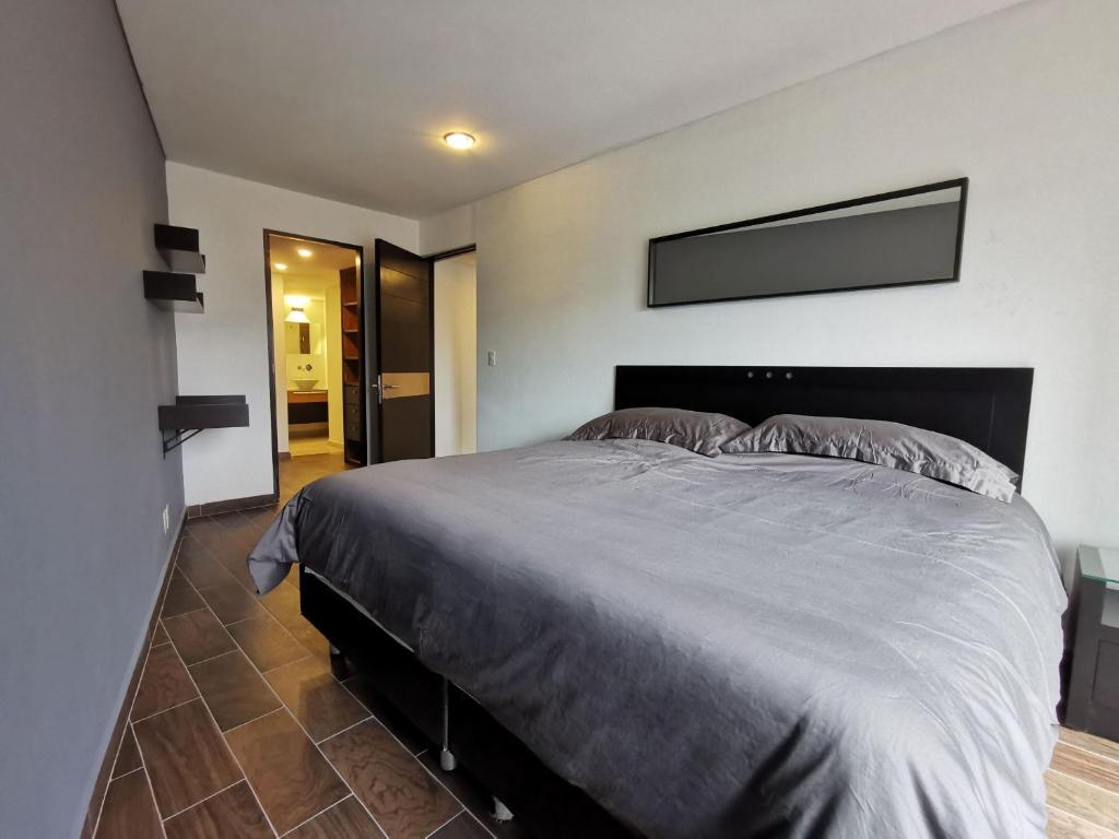 1 dormitorio con 1 cama grande en una habitación en Centric Alure Apartments en Ciudad de México