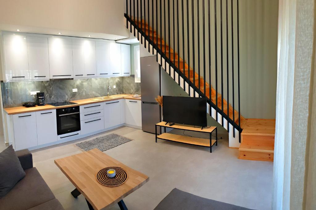 a kitchen with white cabinets and a tv in it at Almeta Suites in Chios