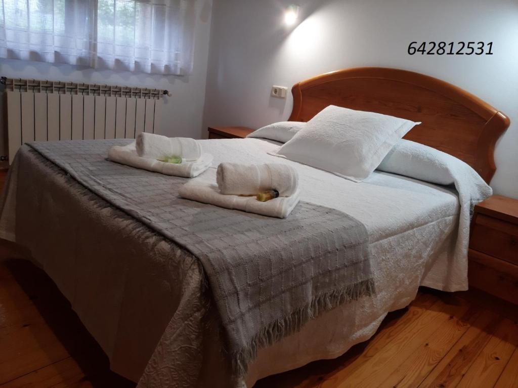 una camera da letto con un letto e due asciugamani di El Puentín del Sella con WiFi y parking gratuito a Cangas de Onís