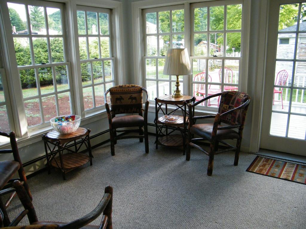 Habitación con sillas, mesa y ventanas. en The Bond 1786 Inn, en Warrensburg