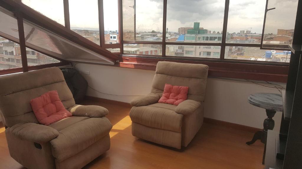 2 sillas sentadas en una habitación con ventanas en cerca aeropuerto embajada EEUU fotos huellas visa, en Bogotá