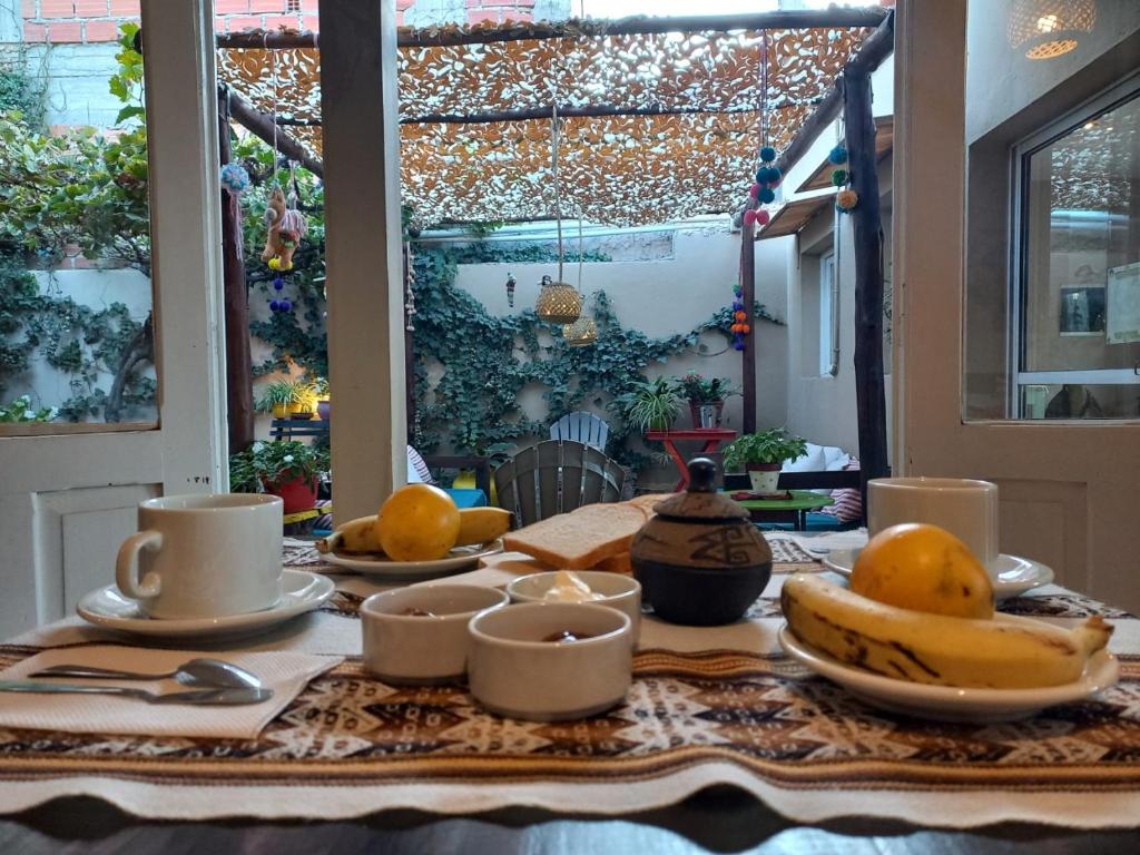 una mesa con plátanos y otras frutas. en La Morada Hostal en Cafayate