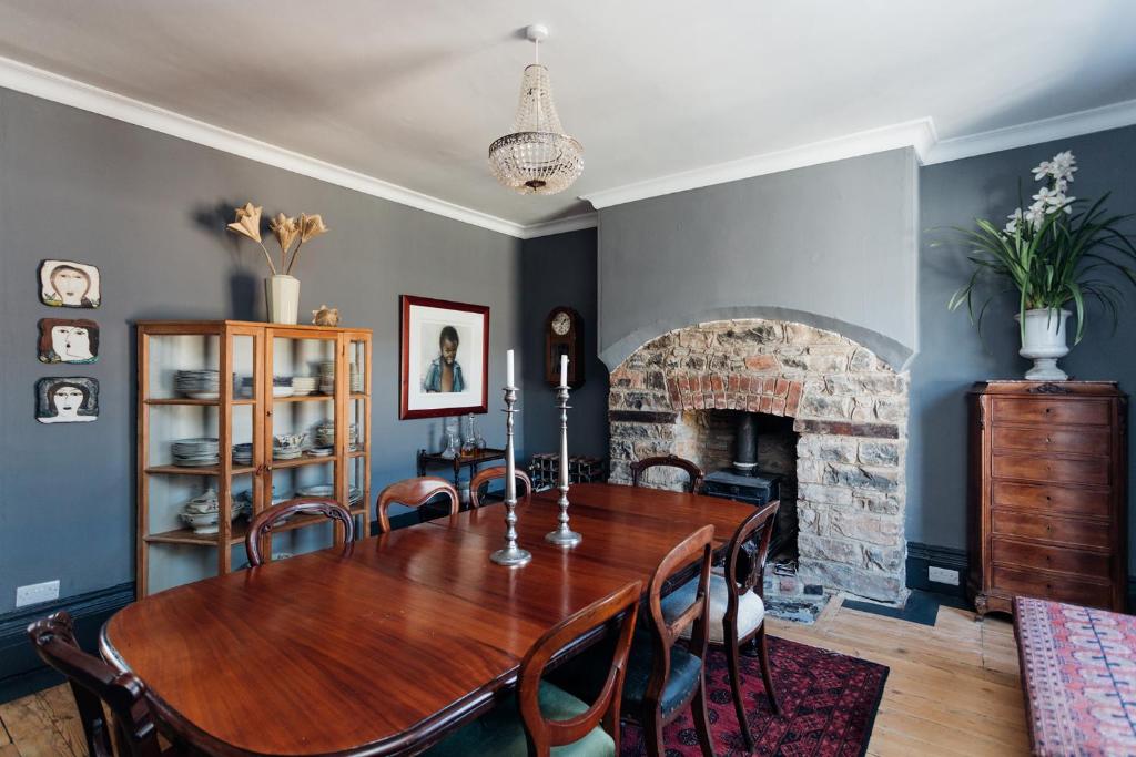 una sala da pranzo con tavolo in legno e camino di Six on Castle a Tiverton