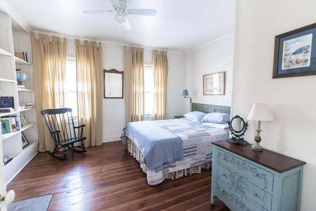 - une chambre avec un lit et une chaise dans l'établissement Armory Quarters A, à Harpers Ferry
