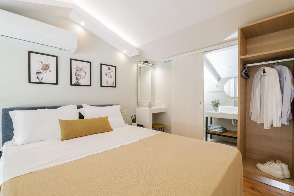 1 Schlafzimmer mit einem großen Bett und einem Badezimmer in der Unterkunft Stylish & elegant loft suite in the city center in Zakynthos