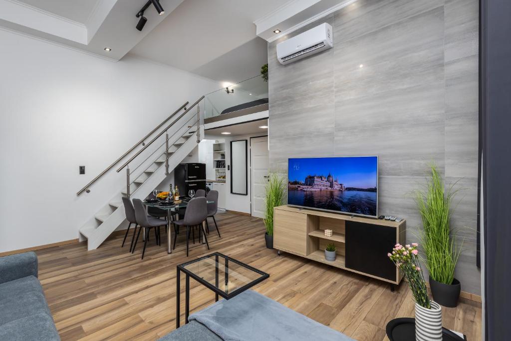 a living room with a couch and a tv and a table at KIRÁLY21 DOWNTOWN Apartment in Budapest