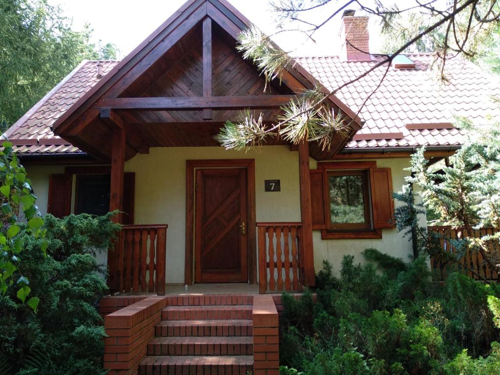 Casa pequeña con puerta de madera y escaleras en Fajny Domek w Nartach, en Narty