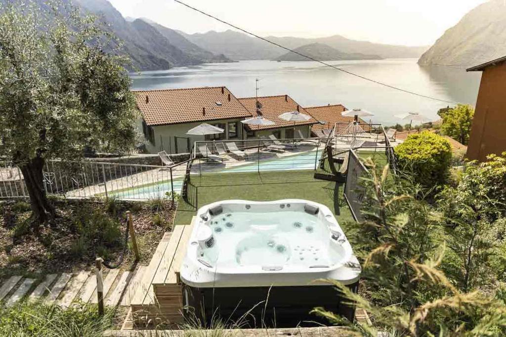 a bath tub sitting on a deck next to a house at Hotel Miranda in Riva di Solto