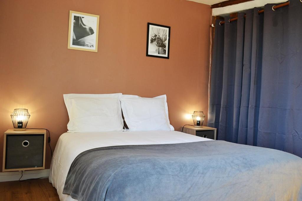 a bedroom with a large bed with two night stands at L'essentiel de Chartres in Chartres