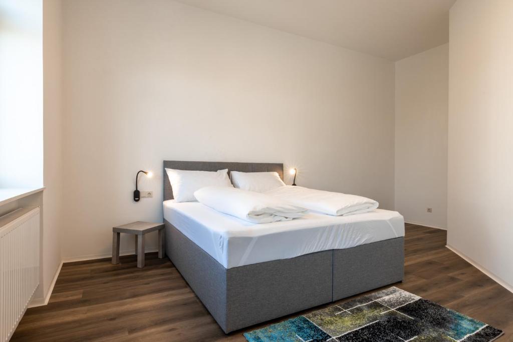 sypialnia z dużym łóżkiem z białą pościelą w obiekcie City Apartments Amstetten w mieście Amstetten