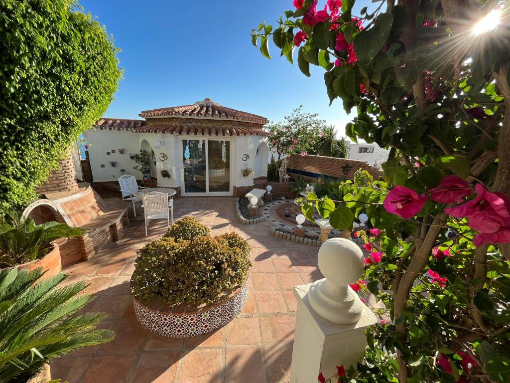 a patio with flowers and plants and a house at Casa Hermosa in Torre de Benagalbón