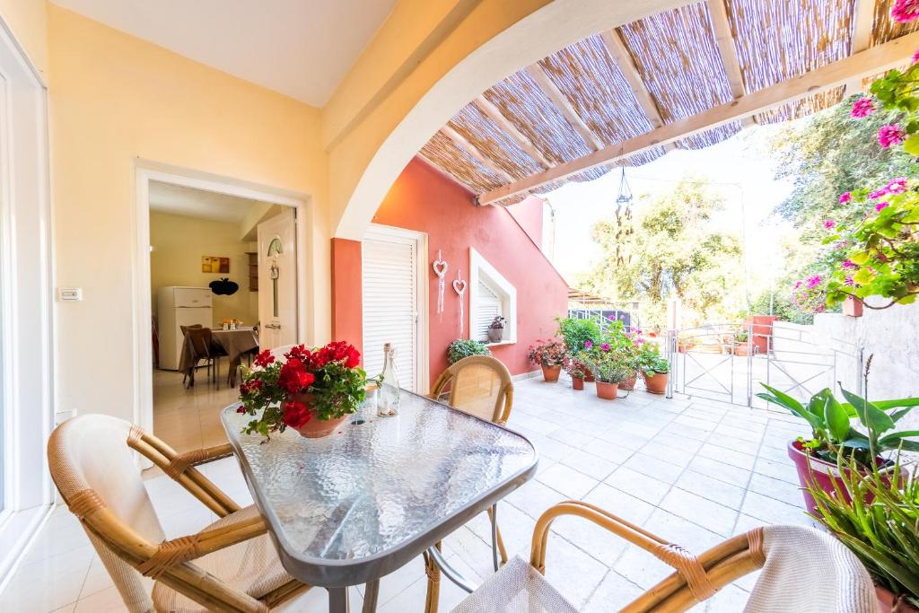 jadalnia ze stołem i krzesłami oraz patio w obiekcie Helen Corfu House w Korfu