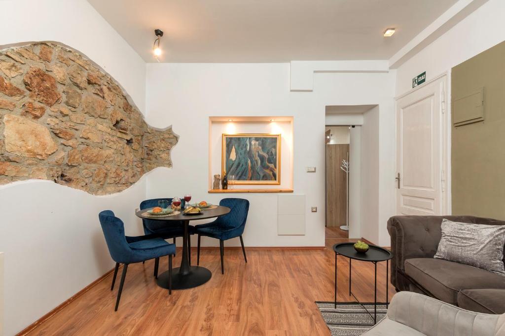 a living room with a table and chairs and a couch at Heisenberg City Residence in Pula