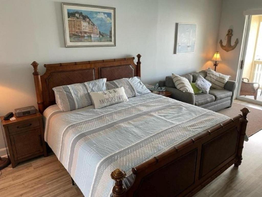 a bedroom with a large bed and a couch at Inn at Camachee Harbor View 23 in Saint Augustine